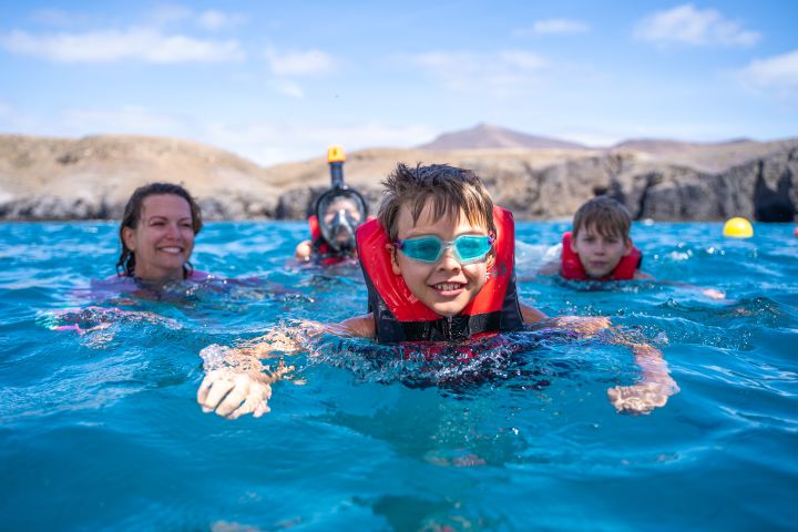 Junge schwimmt mit Familie Lanzarote